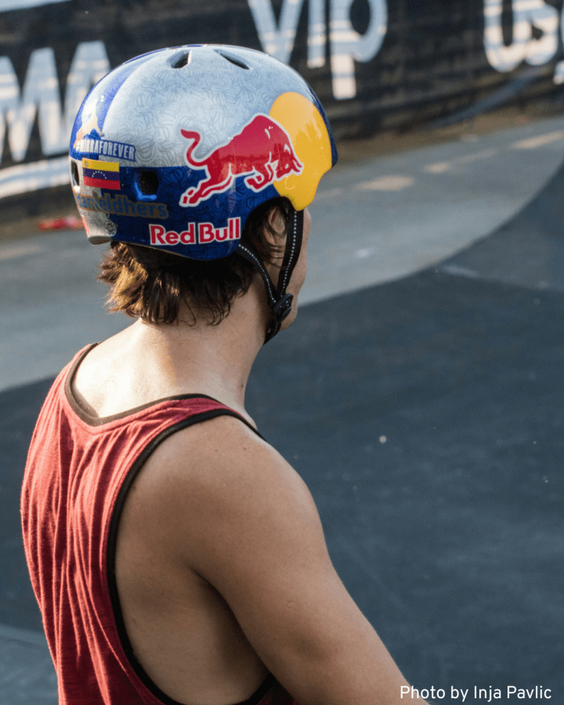 A skater wearing a red bull helmet, emphasizing the importance of safety gear in skateboarding.

