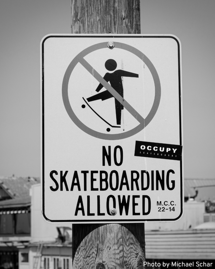 A clear "No Skateboarding Allowed" sign featuring a skateboard icon with a prohibition symbol.
