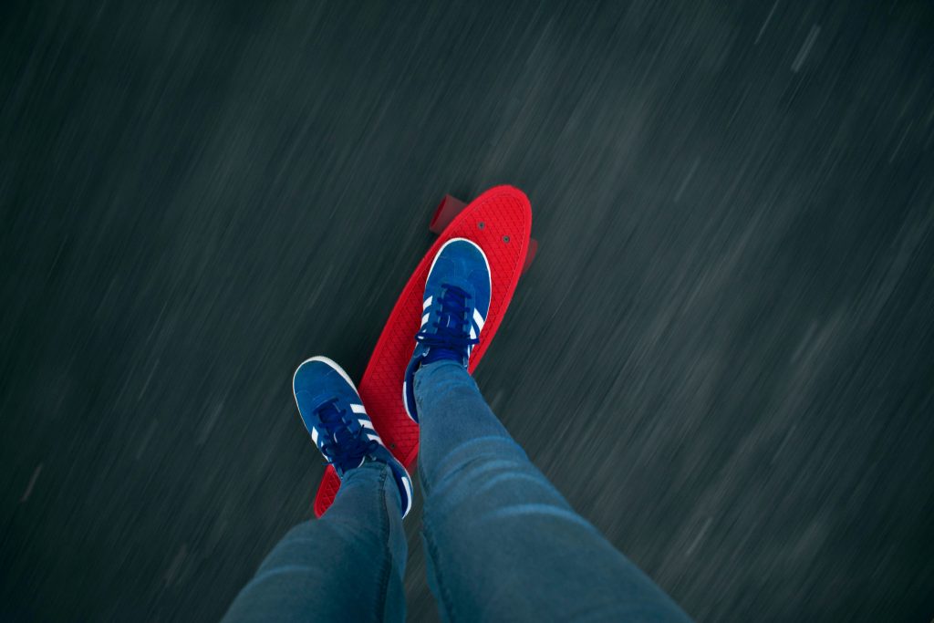 A young adult skillfully rides a penny skateboard on a smooth surface, showcasing their balance and style.