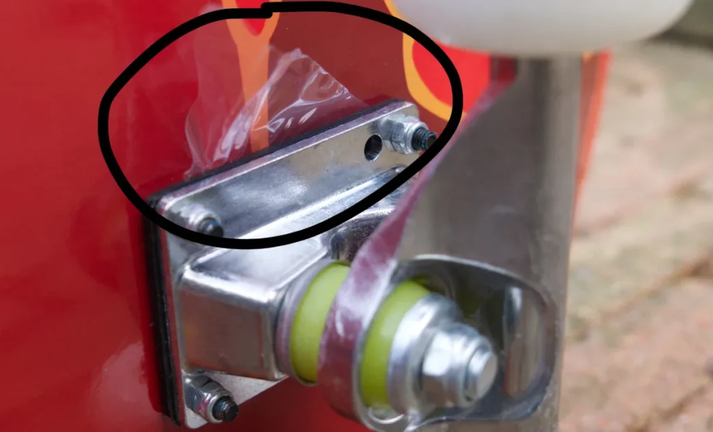 Close-up image of a metal skateboard truck with a plastic cover, illustrating its features for skatershomebase.com.